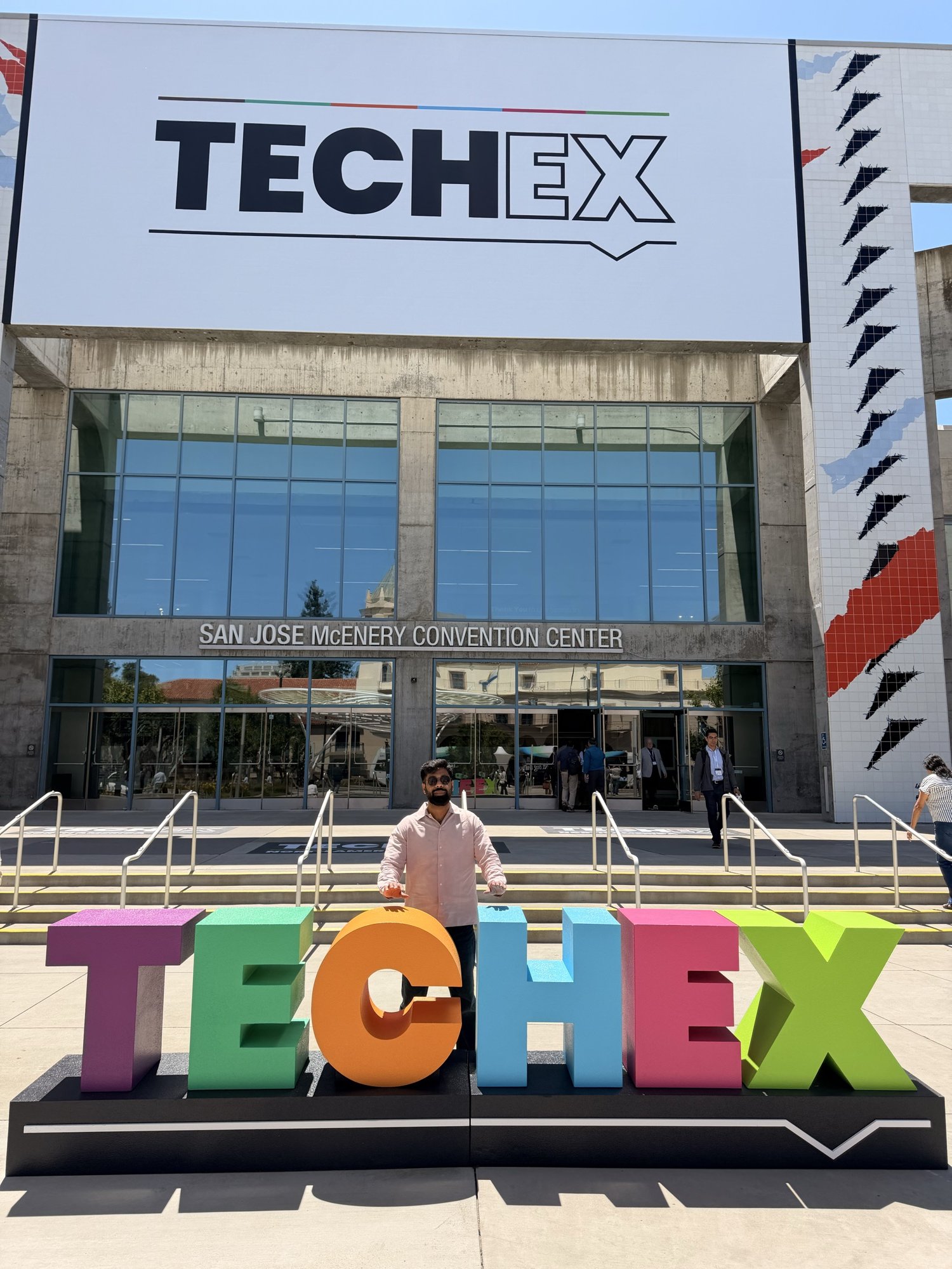 Standing behind colourful TechEx letters outside the San Jose McEnery Convention Center.